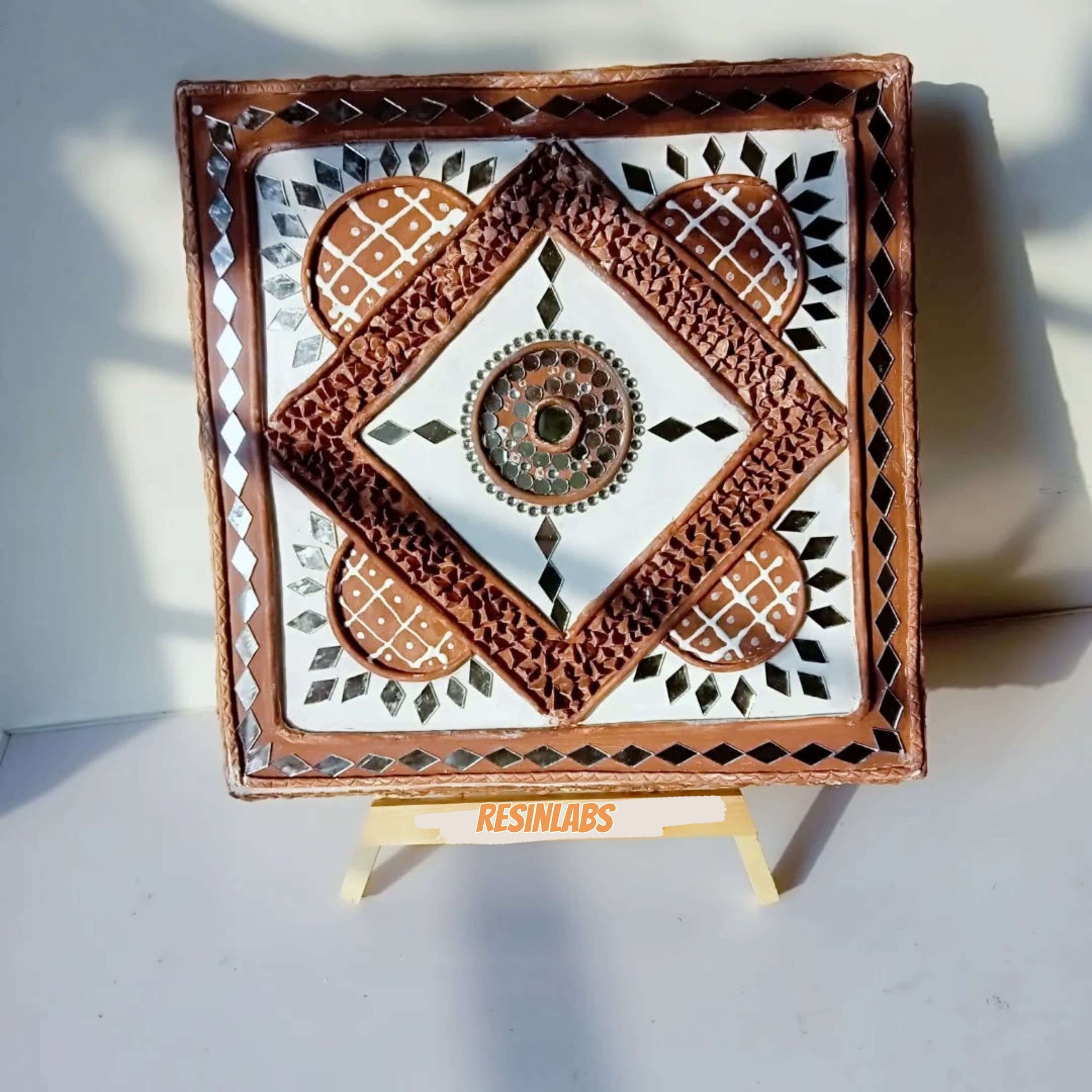 LippanGlow handcrafted mud and mirror art piece with intricate patterns and vibrant colors displayed on easel.